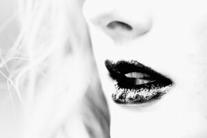Découvrez Murmure Noir, un portrait en noir et blanc intense, jouant sur le contraste captivant des lèvres sombres. Élégance et mystère garantis.