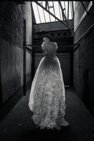 Blanc Captif de Thierry Stentzel, photographie d’Art contemporaine montrant une silhouette en robe blanche dans un bâtiment abandonné, tirage limité noir et blanc.