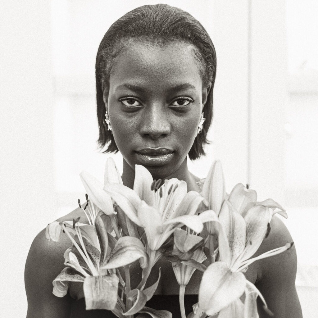 Reste la Force, portrait f&eacute;minin noir et blanc avec fleurs de lys et regard intense, photographie d&rsquo;art contemporaine de Thierry Stentzel