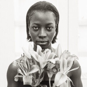 Reste la Force, portrait féminin noir et blanc avec fleurs de lys et regard intense, photographie d’art contemporaine de Thierry Stentzel